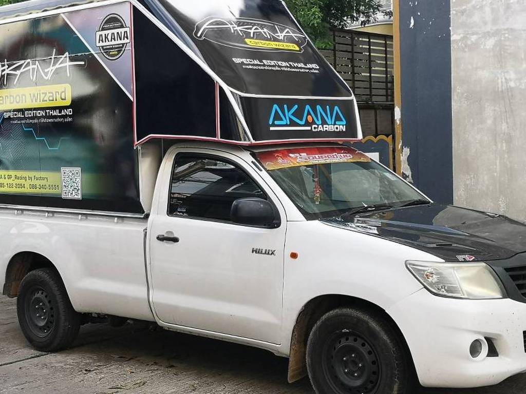 รถกระบะบริษัทแบบตู้ทึบติดตั้งสติ๊กเกอร์โฆษณาเต็มคันรูปแบบ Full Wrap แสดงมุมมองเฉียงหน้าและข้างรถเพื่อสร้างภาพลักษณ์องค์กร