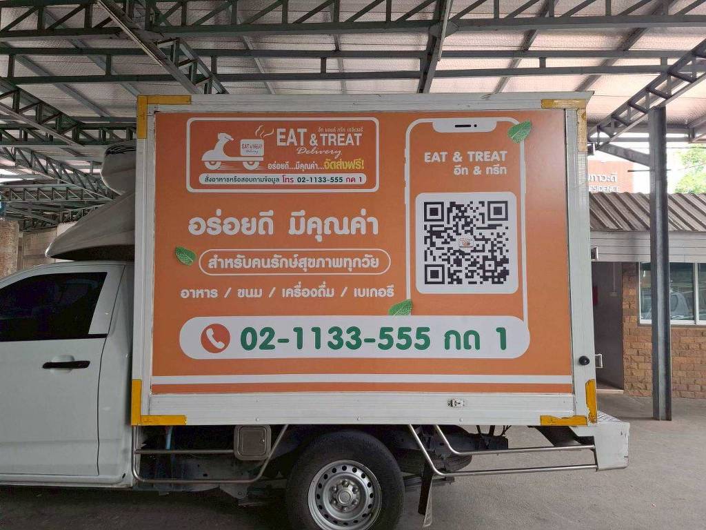 สติ๊กเกอร์รถส่งของ ภาพถ่ายตรงระนาบด้านข้างกล่องตู้บรรจุสินค้าห้องเย็น คุมโทนเฉดสีส้มสดใสตัดตัวหนังสือโลโก้สีขาวนวลเด่นตา
