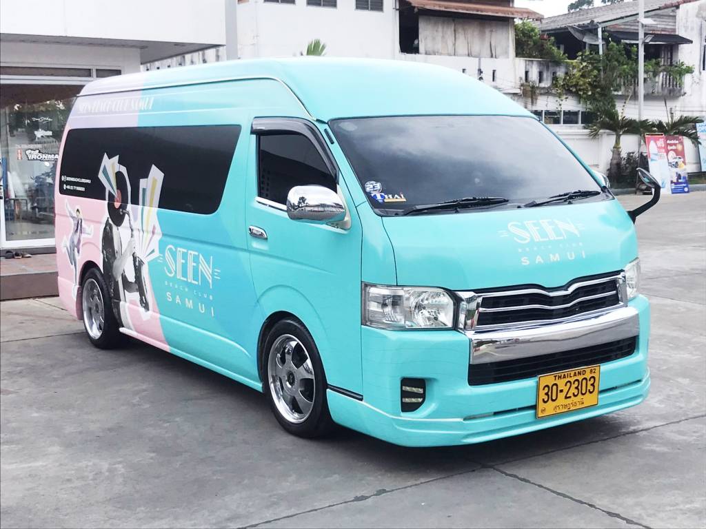 มุมมองด้านหน้าซ้ายของรถตู้ Commuter แร็ปสติ๊กเกอร์ครึ่งคันถึงเต็มคันเชื่อมต่อลวดลายลงตัว