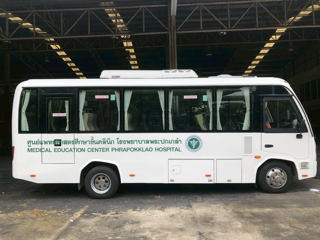 สติ๊กเกอร์แร๊ปรถบริการภาคสนาม ภาพถ่ายโปรไฟล์ด้านข้างเต็มคันรถมินิบัสพยาบาลเคลื่อนที่แบรนด์พระปกเกล้าสีขาวตัดเขียว