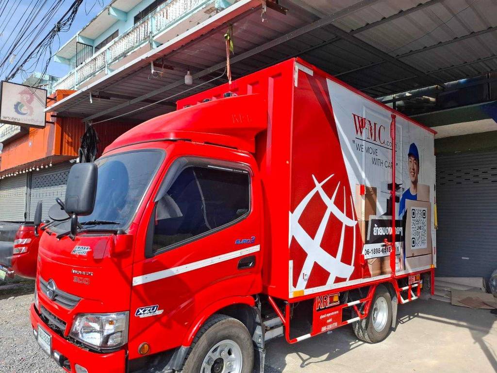 สติ๊กเกอร์แร๊ปรถขนส่งโลจิสติกส์ มุมมองสามส่วนสี่ด้านหน้าฝั่งคนขับรถบรรทุก 4 ล้อใหญ่ โชว์งานแร็ปฟิล์มสีแดงสดปิดทับหัวเก๋งเดิมสีขาวอย่างมิดชิด