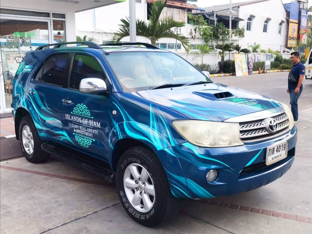 งานแร็ปรถ SUV เต็มคันสำหรับรถทีมขายอสังหาฯ ลายกราฟิกพลิ้วไหวสีเขียวฟ้าตัดน้ำเงินสะดุดตาบนท้องถนน