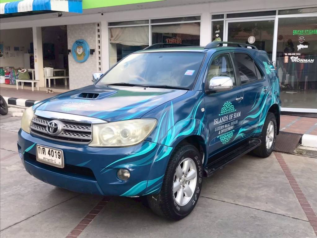 สติ๊กเกอร์รถเซลล์องค์กรติดรถ SUV Toyota Fortuner ลายคลื่นสีน้ำเงิน สำหรับทีมขายอสังหาริมทรัพย์พรีเมียม ผลิตโดย Aura Print