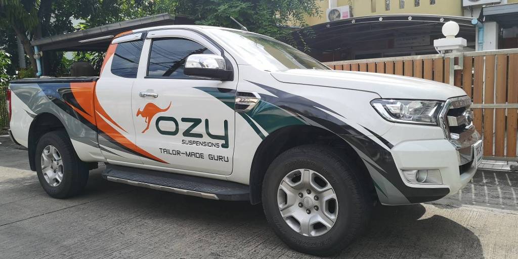 รถกระบะบริษัทแบรนด์ OZY ติดสติ๊กเกอร์ข้างรถที่ออกแบบมาเพื่อสร้างความน่าเชื่อถือตั้งแต่แรกเห็น