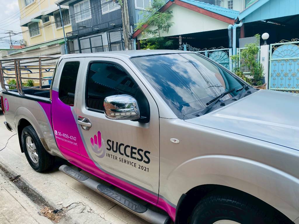 รถกระบะบริษัท SUCCESS ติดสติ๊กเกอร์ข้างรถแสดงเว็บไซต์และเบอร์โทรศัพท์อย่างโดดเด่น