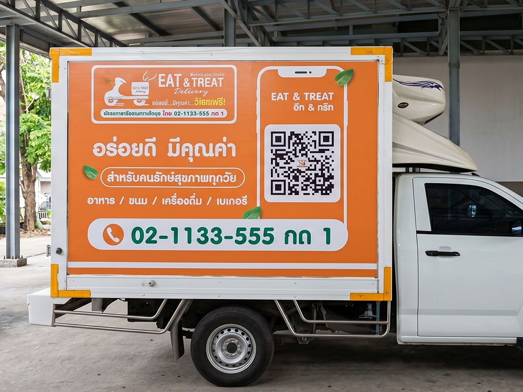 รถกระบะตู้ทึบส่งของติดสติ๊กเกอร์ QR Code ข้างตัวรถ เพื่อนำทางผู้สแกนเข้าสู่หน้าระบบตัวเลือกบริการของธุรกิจ
