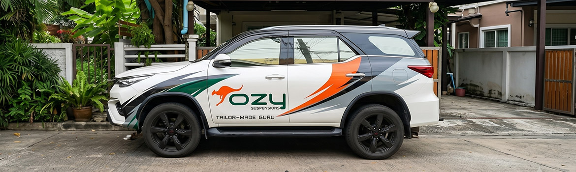 งานติดตั้ง Partial Vehicle Wraps สติ๊กเกอร์ข้างรถบริษัทสีขาวจัดวางโลโก้และสเปกสี CI ตัดกับพื้นผิวรถเดิมอย่างสมดุล