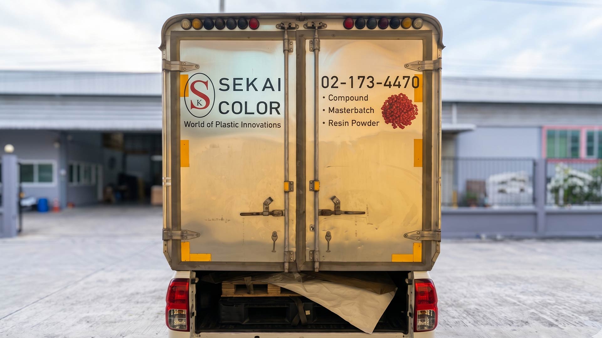 สติ๊กเกอร์ท้ายรถบริษัทประเภทงานไดคัทตัวอักษรเล็กและโลโก้ Sekai Color พร้อมเบอร์โทรศัพท์บนประตูตู้ทึบ