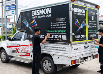 ทีมช่างกำลังทำความสะอาดและติดตั้งสติ๊กเกอร์บนท้ายตู้รถกระบะ Tata แบรนด์ BISMON ตามแผนดูแลและบำรุงรักษางานฟลีทรถองค์กร
