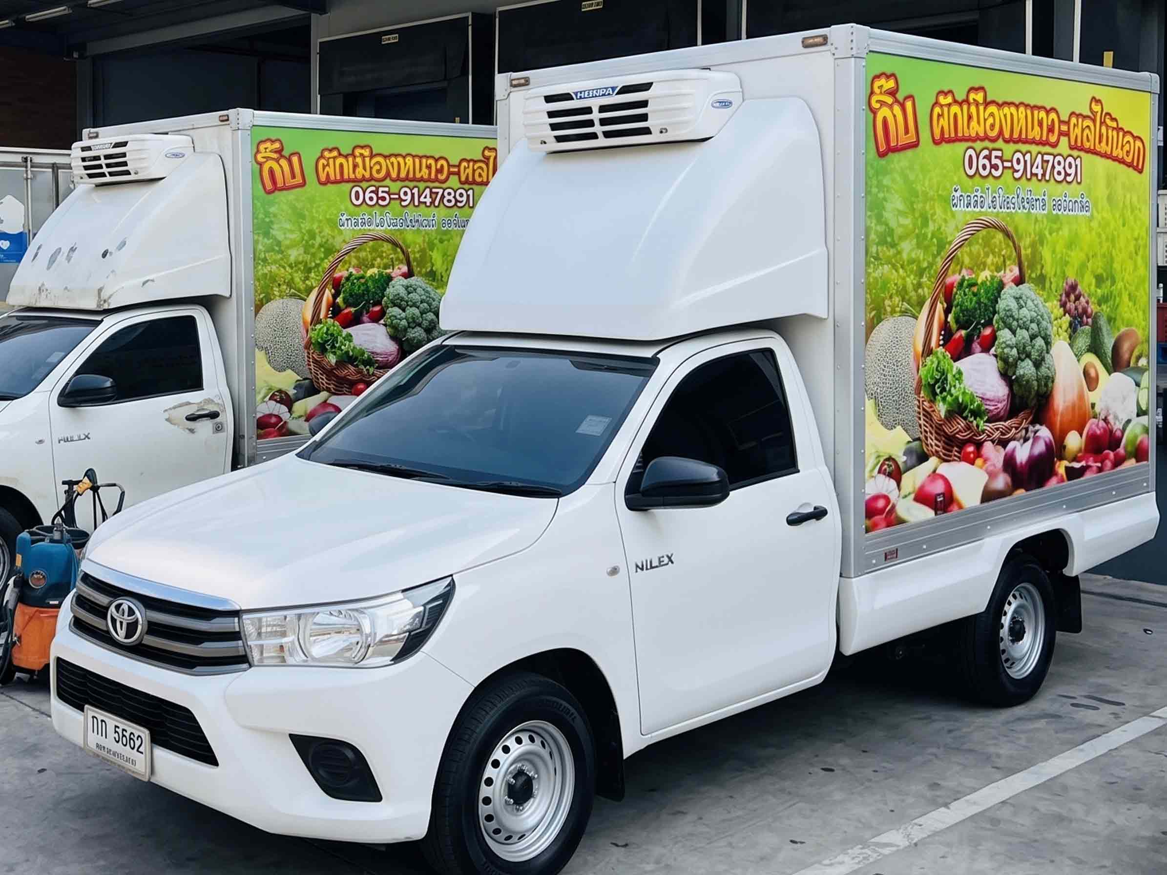 รถกระบะตู้เย็นบรรทุกสินค้าเกษตร Gib Produce สองคัน จอดเทียบเพื่อประเมินสภาพสติ๊กเกอร์ในการดูแลและบำรุงรักษางานฟลีทรถองค์กร