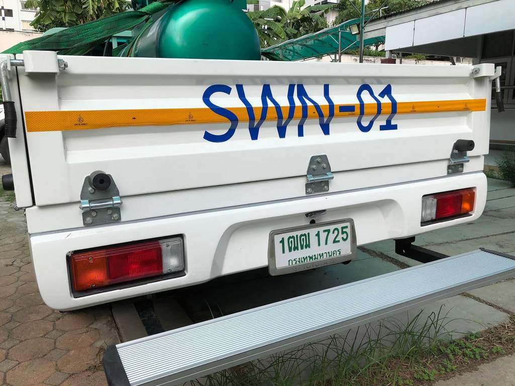 สติ๊กเกอร์เลขรถบริษัทรหัส SWN-01 บนฝาท้ายกระบะส่วนกลางองค์กรร่วมกับแนวแถบสะท้อนแสงเพื่อความปลอดภัย