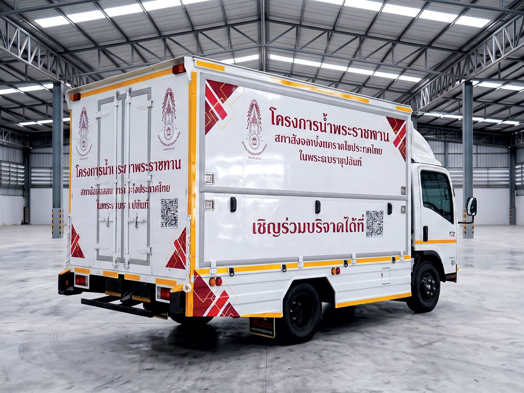 สติ๊กเกอร์รถกิจกรรมและอีเวนต์องค์กร มุมเฉียงท้ายรถบรรทุก Isuzu แสดงการเชื่อมต่อของลวดลายกราฟิกสีแดงทองระหว่างฝาข้างและประตูตู้ท้ายอย่างเป็นเนื้อเดียว