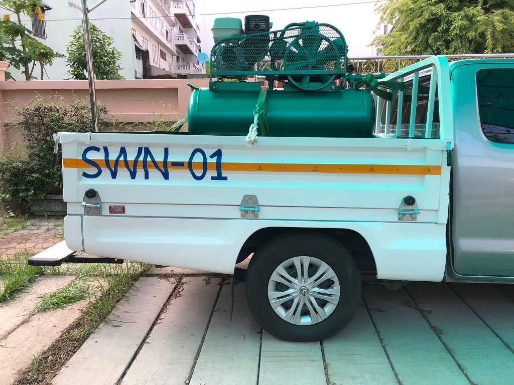 สติ๊กเกอร์เลขรถบริษัทรหัส SWN-01 บนข้างประตูรถกระบะดัดแปลงที่บรรทุกเครื่องมือและปั๊มลมสำหรับงานวิศวกรรม