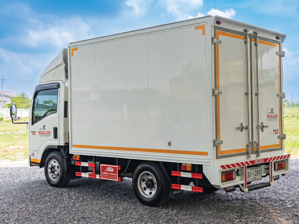 มุมเฉียงท้ายซ้ายรถบรรทุก Isuzu NLR 130 ตู้ทึบสีขาวติดสติ๊กเกอร์ MULLER หลังผ่านกระบวนการรื้อสติ๊กเกอร์เก่าและติดตั้งใหม่