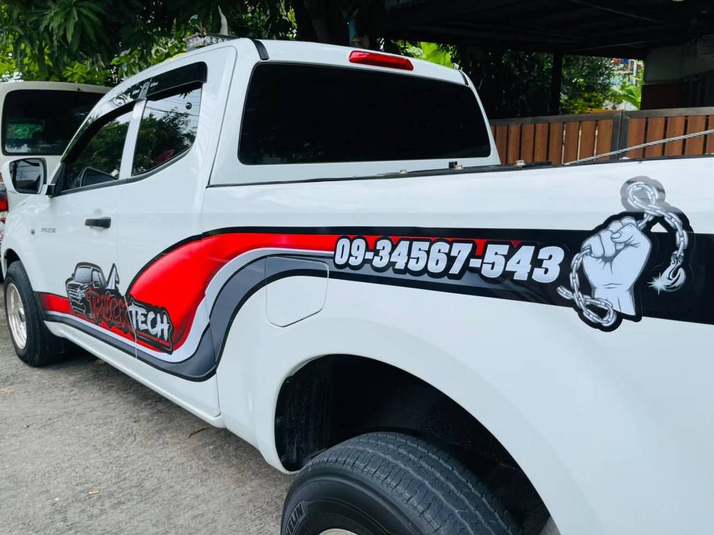 สติ๊กเกอร์เบอร์ติดต่อบนรถกระบะบริเวณตัวถังด้านท้ายแสดงหมายเลข 09-34567-543 ร่วมกับลายกราฟิกสีแดงดำ