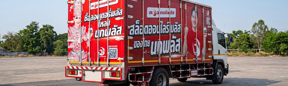 สติ๊กเกอร์ QR Code บนรถบรรทุกตู้ทึบขนส่งสินค้าสีแดงขนาดใหญ่ จัดวางตําแหน่งคิวอาร์โค้ดตัวหนาชัดเจนบริเวณบานประตูท้ายตู้