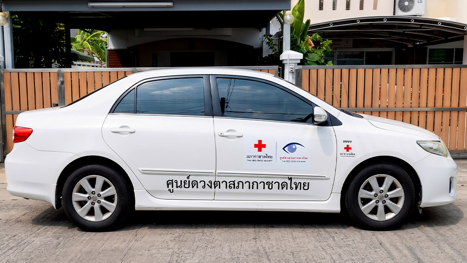 สติ๊กเกอร์ประชาสัมพันธ์เคลื่อนที่เนื้อ PVC พรีเมียม พิมพ์ข้อความและตราสัญลักษณ์ศูนย์ดวงตาสภากาชาดไทย บนรถเก๋งสีขาว