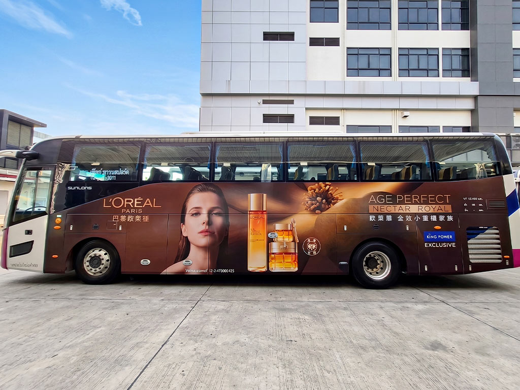 สติ๊กเกอร์รถเปิดตัวสินค้าและแคมเปญ ภาพด้านข้างตรงแสดงความสมมาตรของดีไซน์กราฟิก L'Oréal Paris บนรถบัส