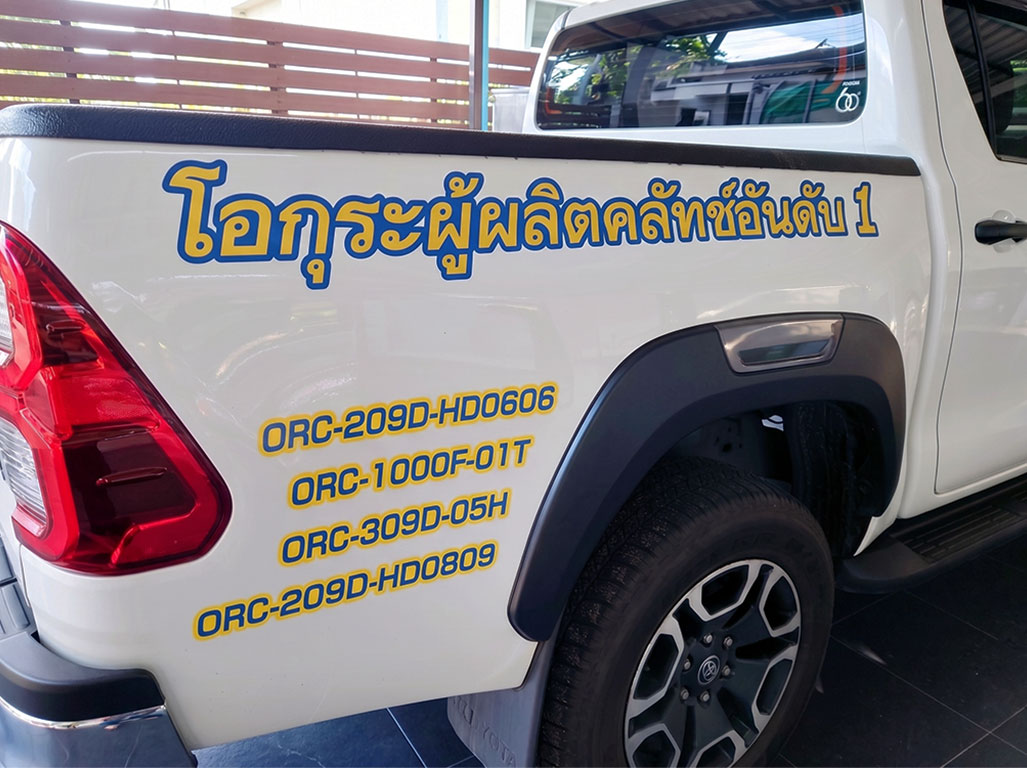 สติ๊กเกอร์ชื่อบริษัทบนรถติดตั้งอักษรภาษาไทยสีน้ำเงินขอบสีเหลืองคมชัดสูงบนตัวถังรถยนต์องค์กรและรหัสตัวเลขเพื่อระบุข้อมูลหน่วยงาน
