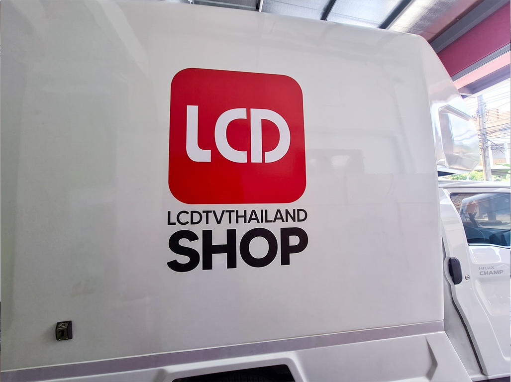 มุมมองแนวตั้งสติ๊กเกอร์ประชาสัมพันธ์เคลื่อนที่ ลายโลโก้ LCD TVTHAILAND SHOP สีแดงดำตัดกับพื้นหลังผิวตู้สีขาวสะอาด