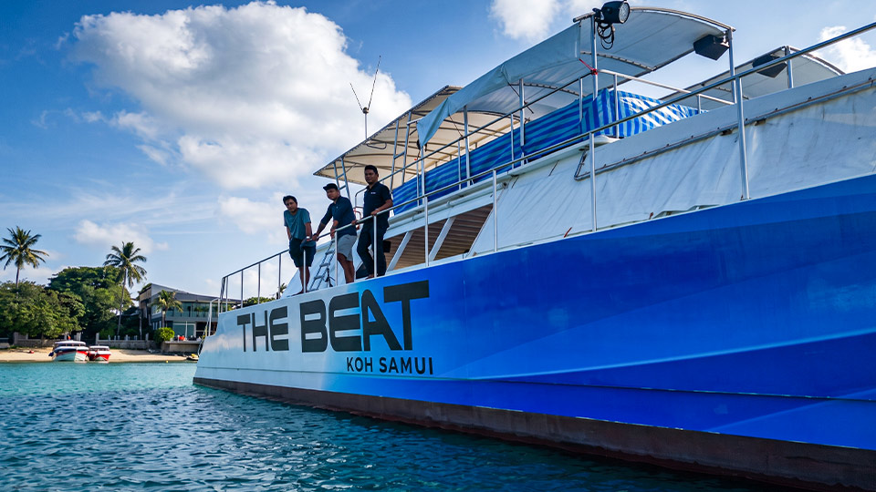 บริการ Wrap เรือคาตามารัน THE BEAT KOH SAMUI ด้วยสติ๊กเกอร์สีน้ำเงินทน UV กลางแดดจัด พร้อมผู้ชาย 3 คนบนเรือ