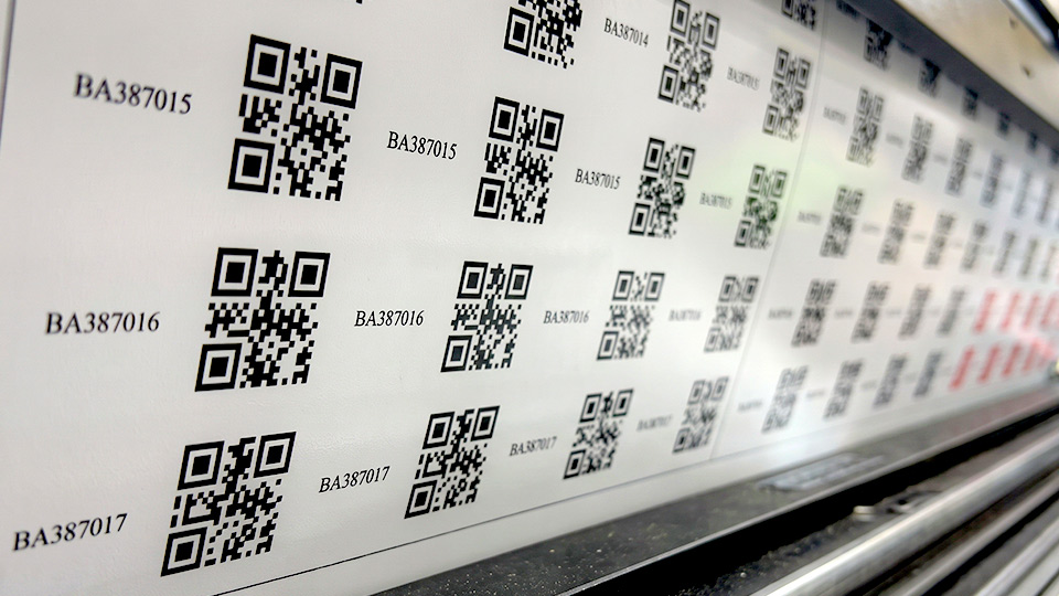 ม้วนงานพิมพ์สติกเกอร์รหัส QR Code และรหัสซีเรียลต่อเนื่องแบบ Multi-SKU บนแท่นเครื่องพิมพ์อุตสาหกรรม