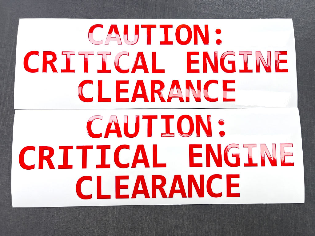 ป้ายความปลอดภัยโรงงาน ภาพมุมตรงของสติ๊กเกอร์ CAUTION CRITICAL ENGINE CLEARANCE 2 แผ่นคู่