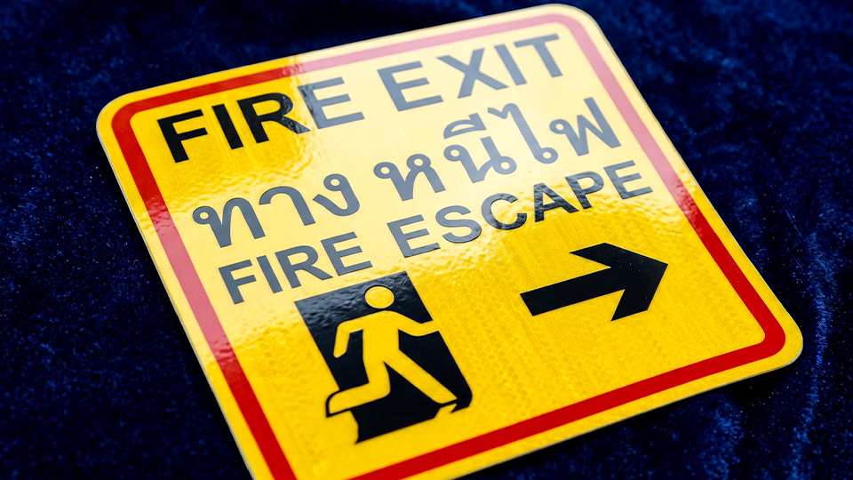 ป้ายทางหนีไฟสะท้อนแสง FIRE EXIT FIRE ESCAPE สีเหลืองขอบแดงพร้อมสัญลักษณ์คนวิ่งและลูกศร สเปก Engineer Grade สำหรับเส้นทางอพยพฉุกเฉินและพื้นที่แสงน้อย