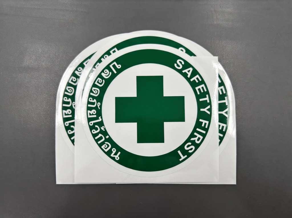 รับทำป้ายความปลอดภัยโรงงาน สติ๊กเกอร์ปลอดภัยไว้ก่อน SAFETY FIRST สัญลักษณ์กากบาทสีเขียว ไดคัทวงกลมเคลือบเงา