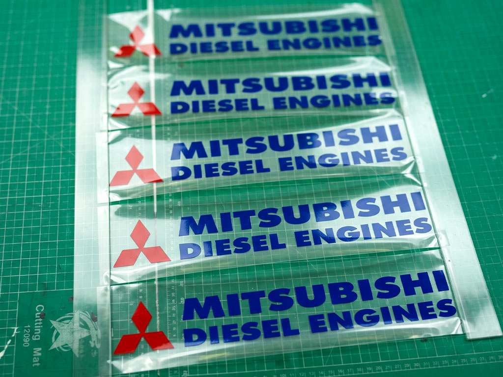 สติ๊กเกอร์ทนความร้อน Mitsubishi Diesel Engines โลโก้เพชรสีแดง ตัวอักษรสีน้ำเงิน บนแผ่นฟิล์มใส