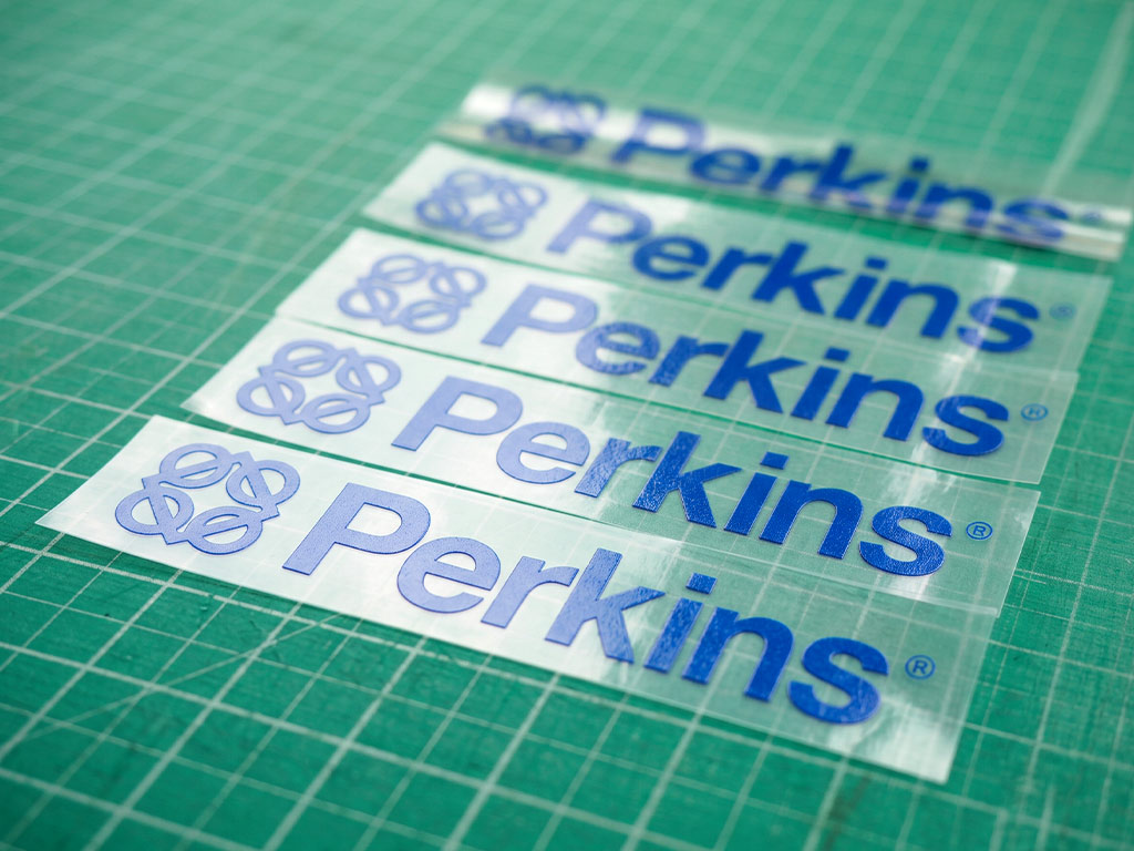 สติ๊กเกอร์ทนความร้อนฟิล์มใส โลโก้ Perkins มุมเฉียง แสดงความเงางามและเส้นสายตัวอักษรที่ชัดเจน