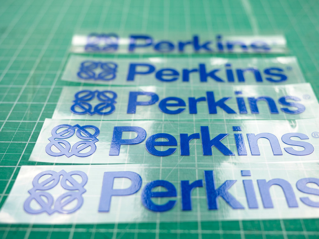 สติ๊กเกอร์ทนความร้อนผิวเคลือบเงา พิมพ์ข้อความ Perkins พร้อมสัญลักษณ์วงแหวน 4 วง คมชัด