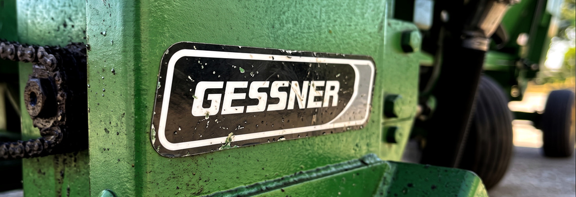 สติ๊กเกอร์ทนความร้อนและจาระบี GESSNER พื้นดำตัวอักษรขาว ติดบนโครงสร้างเครื่องจักรสีเขียวใกล้ชุดโซ่ขับเคลื่อน ทนแรงสั่นสะเทือนและคราบน้ำมัน