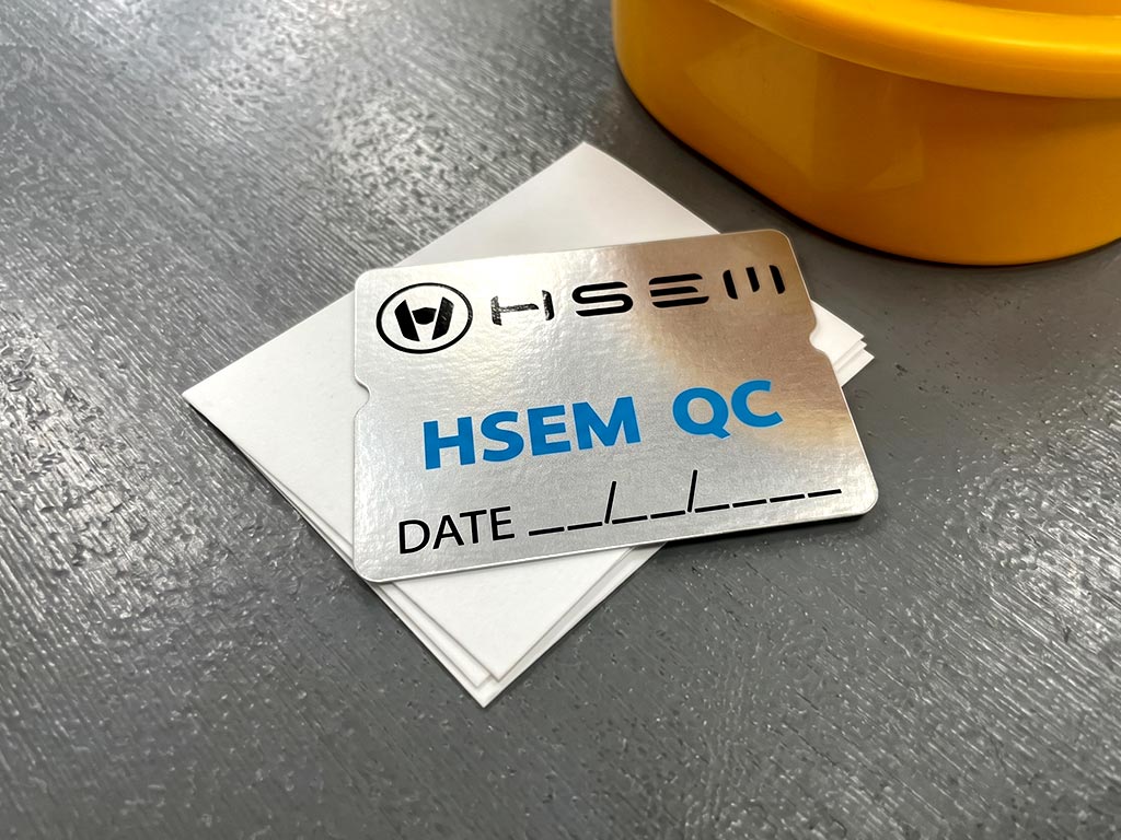 ฉลาก QC, Lot, Batch และ Traceability สติ๊กเกอร์ฟอยล์เงิน HSEM QC โลโก้คมชัดพร้อมช่องลงวันที่ DATE มุมมองบน