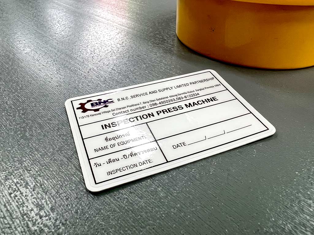 ฉลาก QC, Lot, Batch และ Traceability ป้าย INSPECTION PRESS MACHINE วางบนพื้นผิวปฏิบัติงานข้างแท่นเครื่องจักร