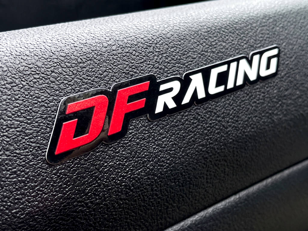 รับทำสติ๊กเกอร์กาวเหนียวพิเศษ ติดพื้นผิวขรุขระ โลโก้ DF RACING ตัวอักษรสีแดงและขาว แนบสนิทบนผิวพลาสติกลายเกล็ดหยาบ