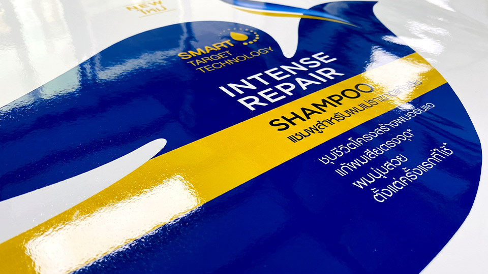 รับผลิตสติ๊กเกอร์ฉลาก อย. ฉลากแชมพู Intense Repair เคลือบฟิล์มเงาขับสีน้ำเงินตัดเหลืองทอง ตัวพิมพ์ข้อความเคลมสรรพคุณคมชัดสะดุดตา