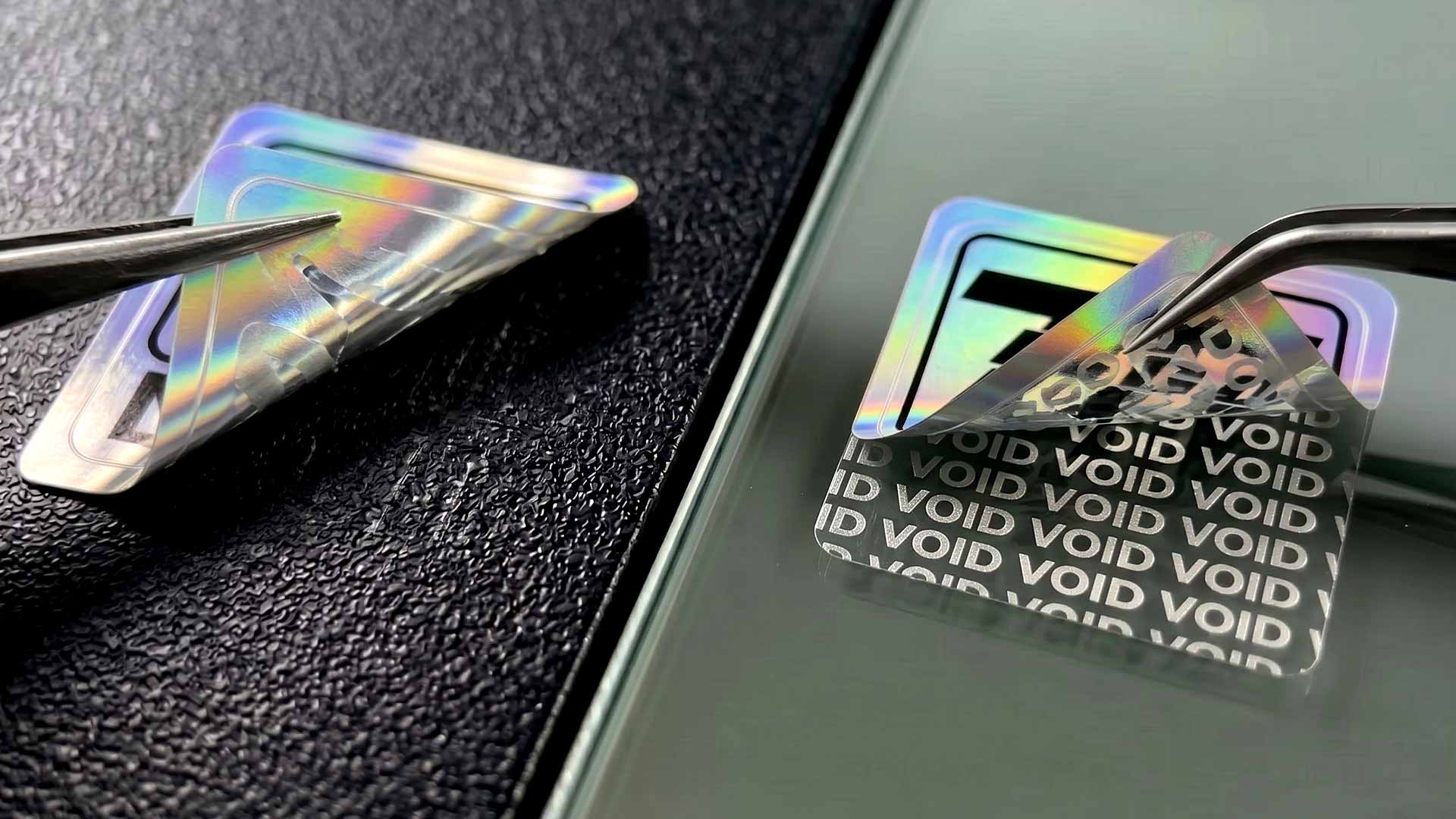 การทดสอบเปรียบเทียบสติกเกอร์กันปลอม VOID บนผิวพลาสติกหยาบและผิวกระจกเรียบเนียน แสดงความแตกต่างของรอยเปิด