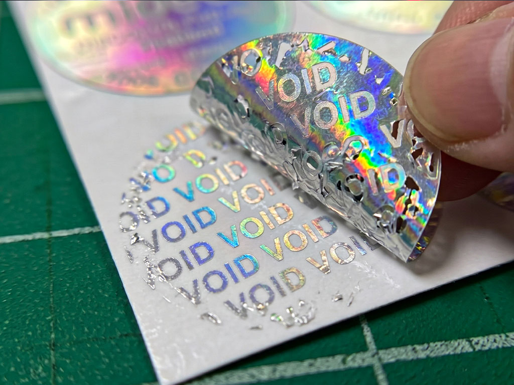 การลอกทดสอบ สติกเกอร์แสดงร่องรอยเมื่อเปิด กันปลอม ทิ้งคราบอักษร VOID สีรุ้งชัดเจนบนพื้นผิว